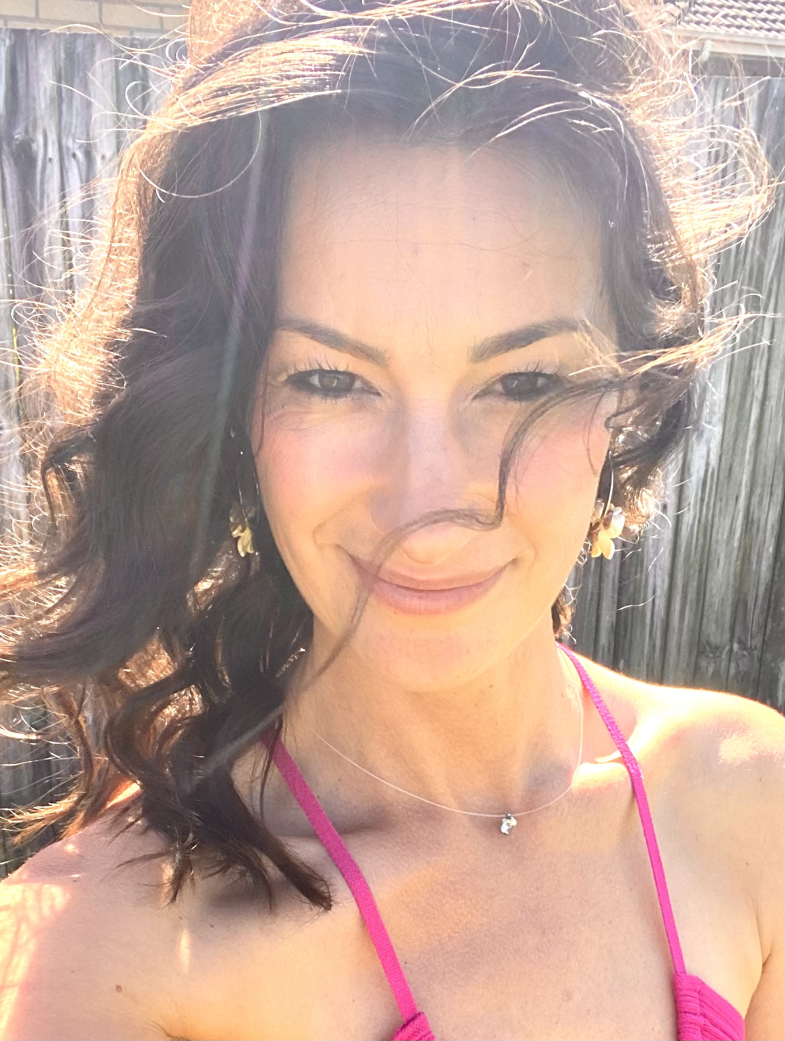 Close-up of Anika smiling in warm sunlight, embodying self-love and personal growth as a spiritual coach